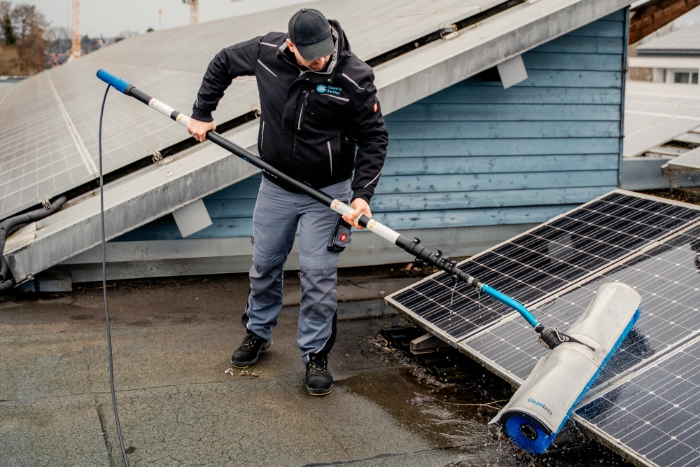 CleanFix Service Photovoltaik Reinigung Bürste Flachdach Techniker reinigt Solarmodule auf Flachdach mit Rundbürste und Teleskopstange — CleanFix Service